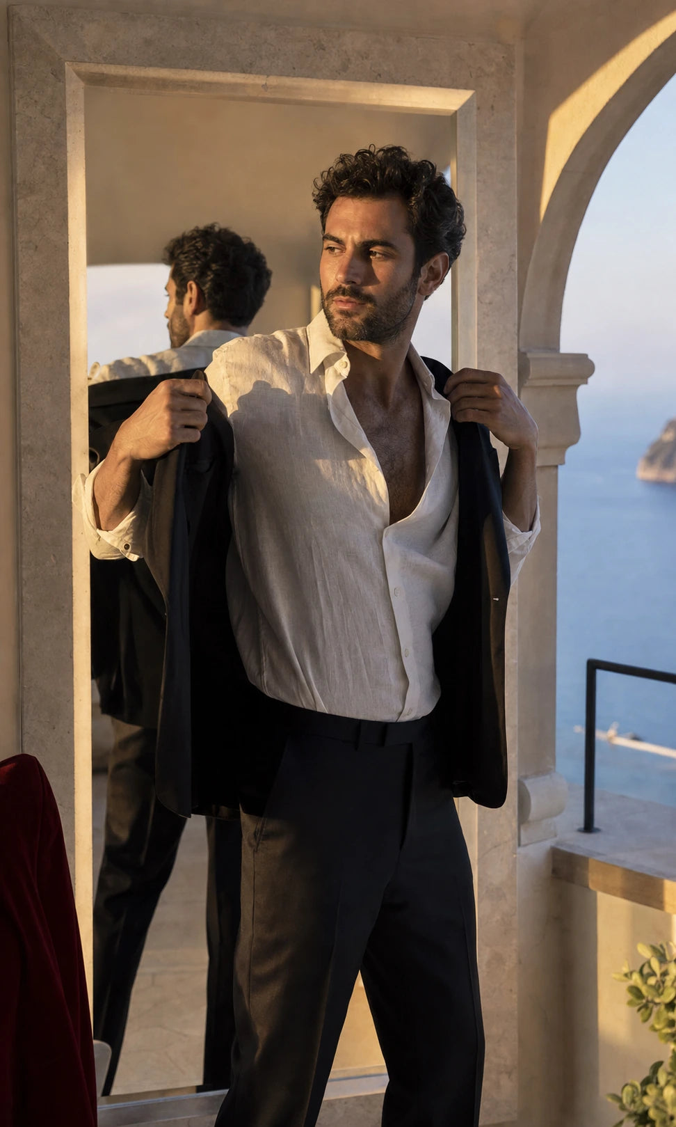 Man getting ready in an ivory linen shirt and tailored black jacket at a limestone resort