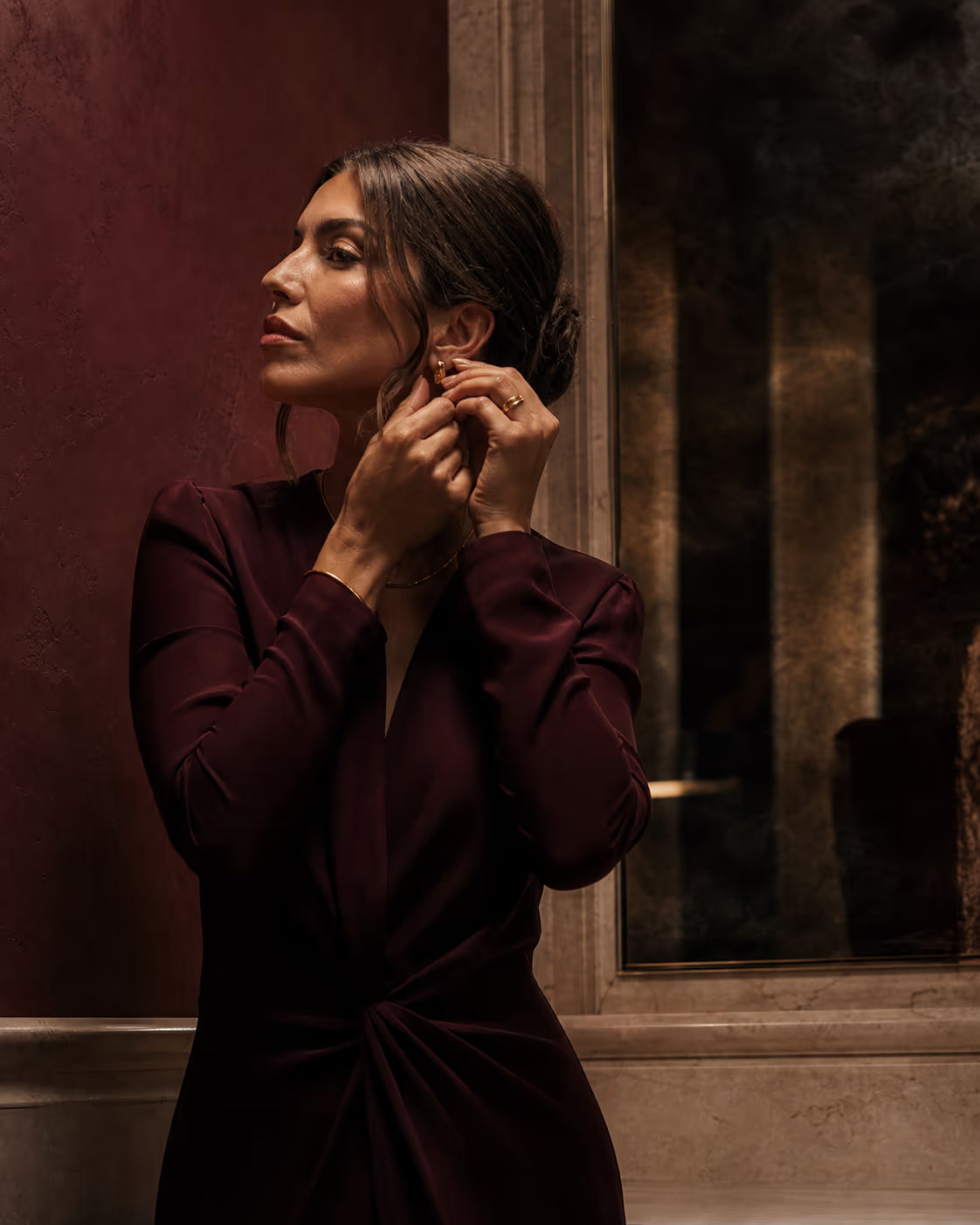 Woman getting ready in an elegant deep-wine dress