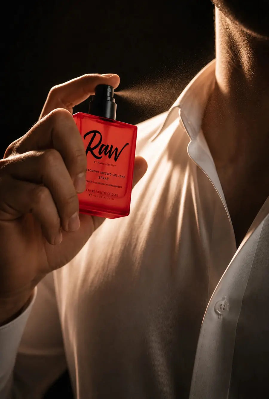 A man applying RAW pheromone-infused cologne before going out
