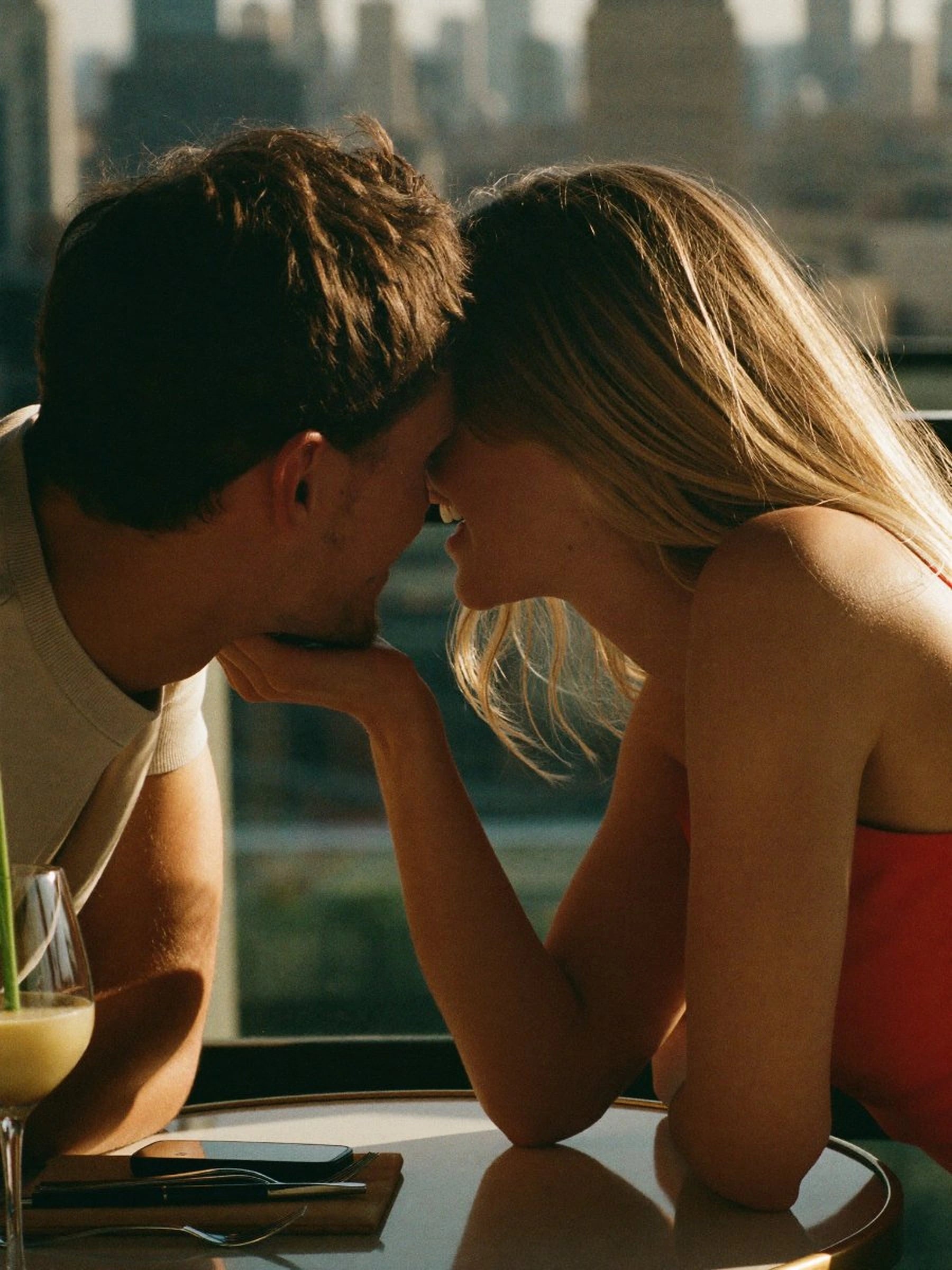 A couple leaning toward each other across a table