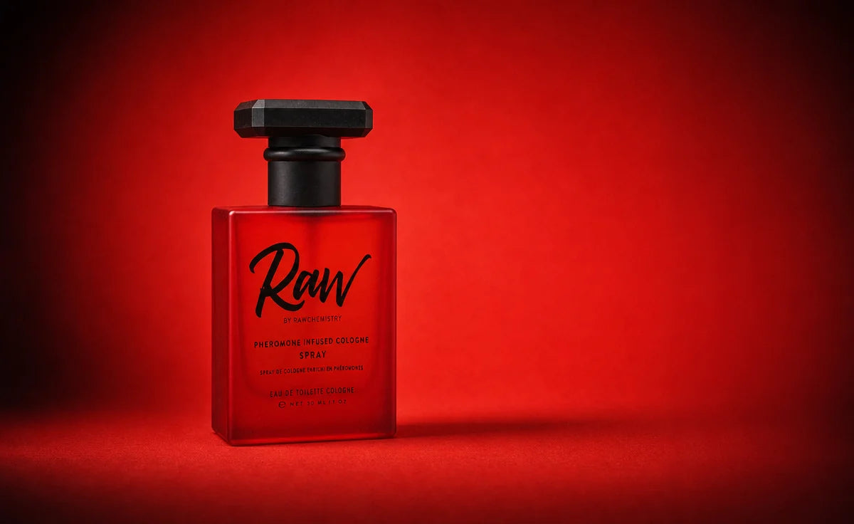 A single full-size RAW pheromone cologne spray, its frosted scarlet glass and matte black cap shown close
