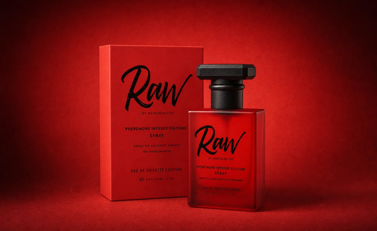 A full-size RAW pheromone cologne spray standing beside its printed scarlet carton